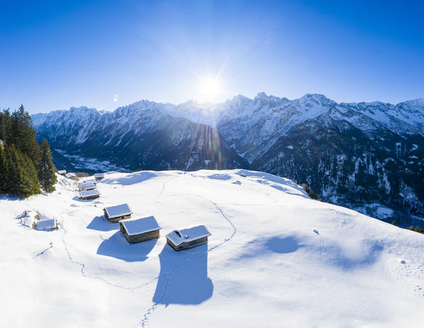 Aerial view of Alp Tombal, with the sun in the background. Soglio, Val Bregaglia, Canton of Grisons, Switzerland, Europe.