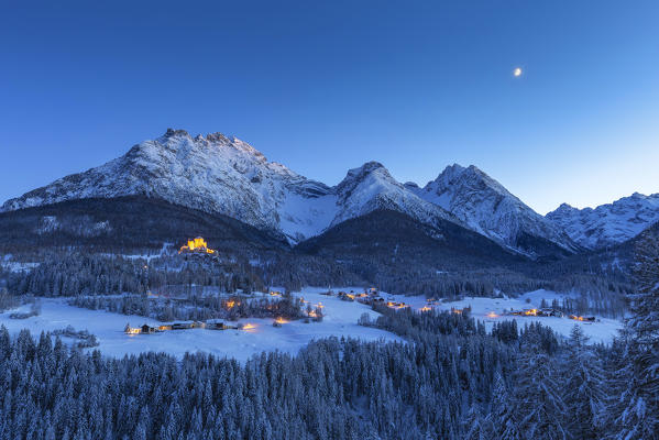 Tarasp Castle and the moon at twilight. Tarasp,  Lower Engadine, Canton of Grisons, Switzerland, Europe.