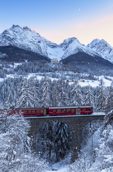 Bernina Express transit on the viaduct in winter. Lower Engadine, Canton of Grisons, Switzerland, Europe.