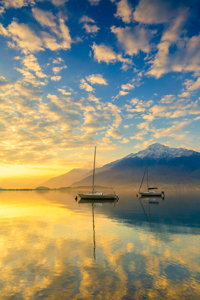 Colours of the sunrise is reflected in the water. Como Lake, Lombardy, Italy, Europe.