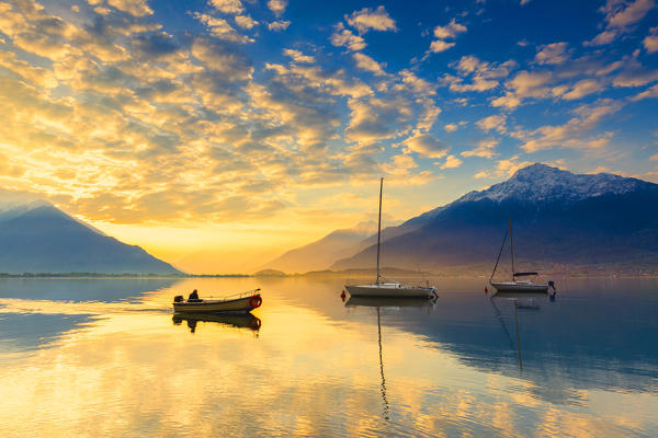 A fisherman boat sales during sunrise. Como Lake, Lombardy, Italy, Europe.