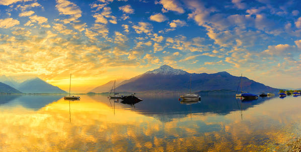 Colours of the sunrise is reflected in the water. Como Lake, Lombardy, Italy, Europe.