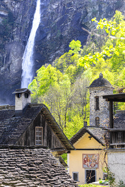 Traditional houses and church of Foroglio with the waterfall in the background, Val Bavona, Canton of Ticino, Switzerland, Europe.