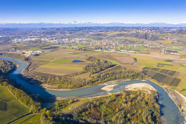 Aerial view of Tanaro river with Alps and Monviso peak in the background. Barbaresco region, Piedmont, Italy, Europe.