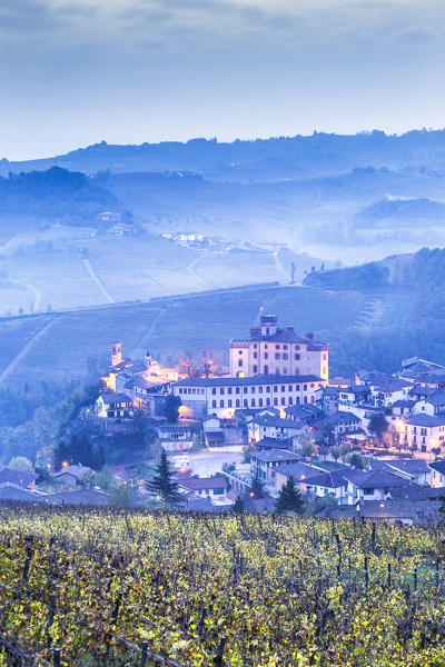 Castle and village of Barolo during a foggy dusk. Barolo wine region, Langhe, Piedmont, Italy, Europe.