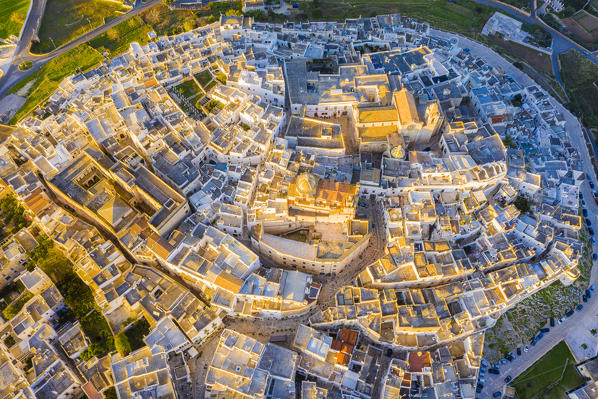 Zenithal aerial view of the old town of Ostuni at sunset, Apulia, Italy, Europe.