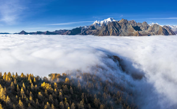 Fog covers the Valmalenco(Val Malenco) with the mountain range of Disgrazia in the background. Valtellina, Lombardy, Italy, Europe.