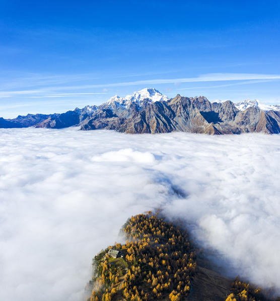 Fog covers the Valmalenco(Val Malenco) with the mountain range of Disgrazia in the background. Valtellina, Lombardy, Italy, Europe.