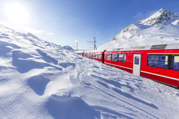 Bernina Express transit at Bernina Pass in winter, Engadin, Canton of Graubunden, Switzerland, Europe.