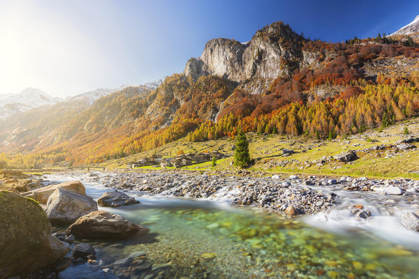 Alpine torrent with view on the alpine village in autumn. Val Bodengo, Valchiavenna, Valtellina, Lombardy, Italy, Europe.