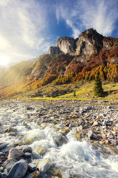 Alpine torrent with view on the alpine village in autumn. Val Bodengo, Valchiavenna, Valtellina, Lombardy, Italy, Europe.