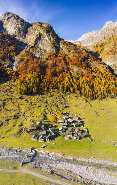 Alpine torrent with view on the alpine village in autumn. Val Bodengo, Valchiavenna, Valtellina, Lombardy, Italy, Europe.