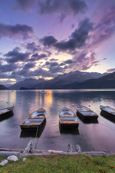 Moored boats in the Lake of Sils at sunrise. Maloja pass, Engadine valley,  Graubunden, Switzerland, Europe.