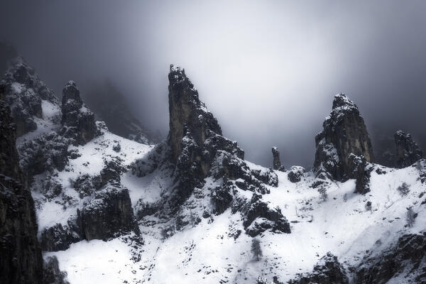 Foggy atmosphere  with light on rock pinnacles. Grignetta, Grigne group, Lake Como, Lombardy, Italy, Europe