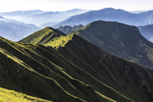 Illuminated ridges at Cima Pari. Ledro lake from Cima Pari. Trento province, Trentino Alto Adige, Italy, Europe.