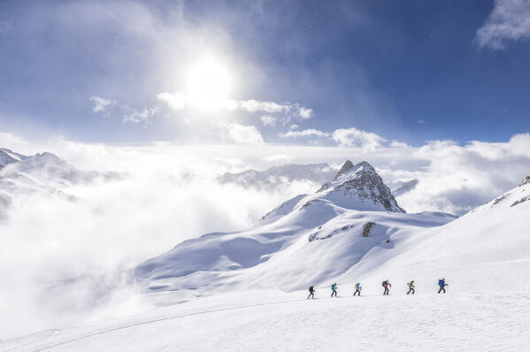 Group of ski mountaineerings in Val D'Agnel with view on Piz Bardella. Julier Pass, Canton of Graubunden, Switzerland, Europe.