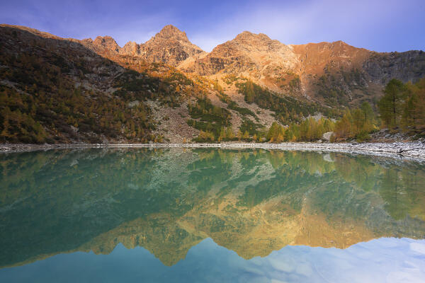 Punta Rosalba and Cima del Duca is reflected in the Lake Lagazzuolo at sunrise in autumn. Valmalenco, Valtellina, Lombardy, Italy, Europe.