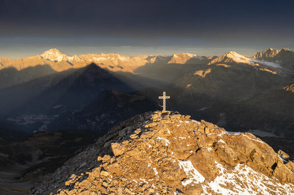 Aerial view of the crucifix on the top of Pizzo Scalino with view on the Mount Disgrazia at sunrise. Valmalenco, Valtellina, Lombardy, Italy, Europe.