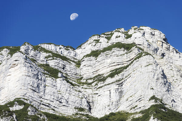 Moon above Vigolana peak. Altopiano della Vigolana, Trento province, Trentino Alto Adige, Italy, Europe.