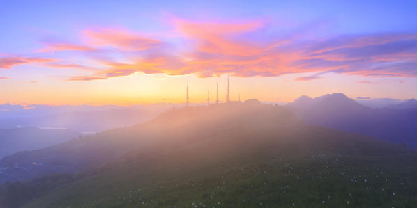 Television antennas in the fog during stunning sunset.  Valico di Valcava(Valcava Pass), Val San Martino, Prealpi Bergamasche, Bergamo province, Lombardy, Italy.