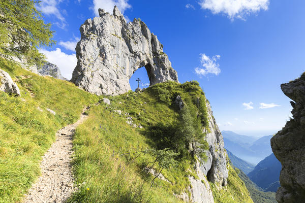 A path leads to Porta di Prada,  a rock natural arch in the Grigna group. Grigna Settentrionale(Grignone), Northern Grigna Regional Park, Lombardy, Italy, Europe.