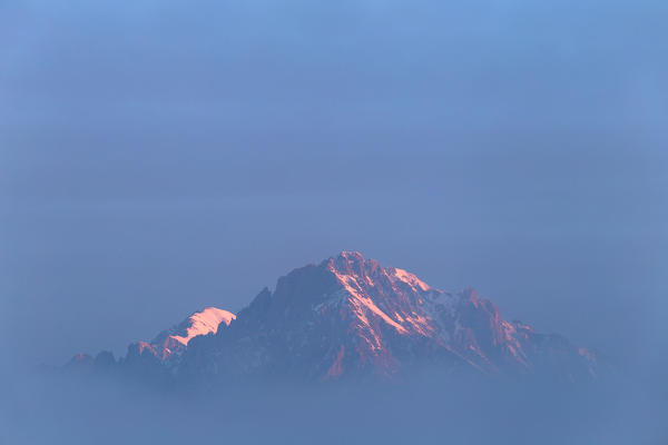 Sunrise on the Grignetta peak, hidden by fog. Grigne group, Lecco,  Brianza, Lombardy, Italy, Europe.