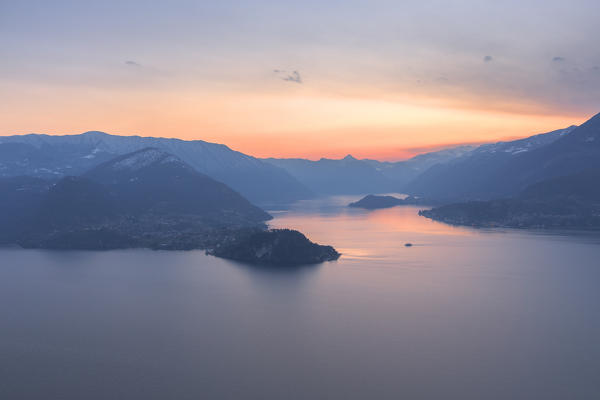 A boat is going to reach the village of Bellagio at sunset. Como Lake, Lombardy, Italy, Europe.