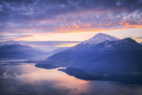 Sunrise on Como Lake and Valtellina with snow-covered Monte Legnone from above. San Bernardo Church, Monte Bregagno, Dongo, Como Lake, Lombardy, Italy, Europe.