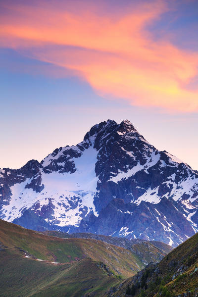 Colourful clouds above Mount Disgrazia during sunrise. Valtellina, Lombardy, Italy, Europe.