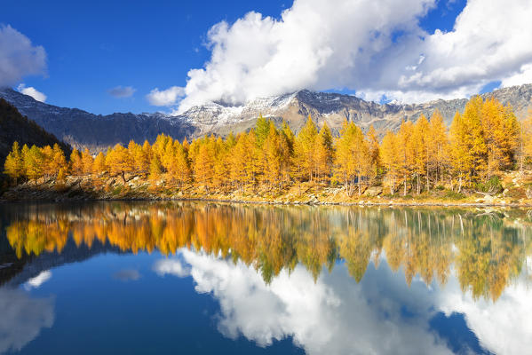 The cluds are reflected in the Lagazzuolo Lake in autumn. Malenco Valley, Valtellina, Lombardy, Italy, Europe