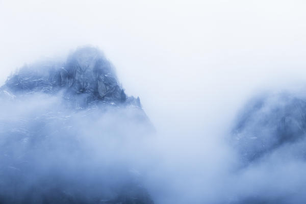 Mountain of the Mello Valley hidden by clouds. Val di Mello, Valmasino, Valtellina, Lombardy, Italy, Europe.