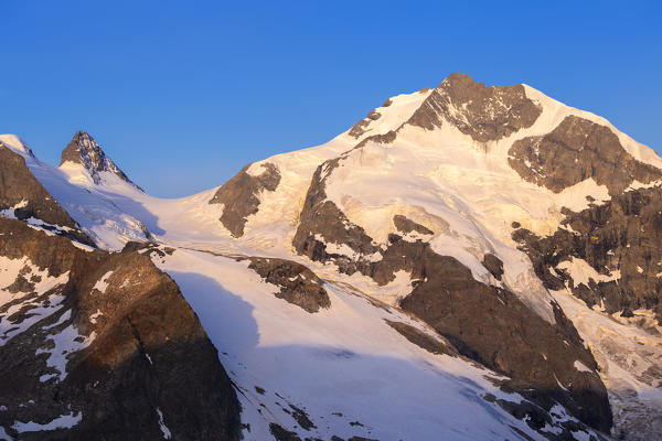 Piz Bernina and Cresta Aguzza at sunrise.  Diavolezza Refuge, Bernina Pass, Engadin, Graubünden, Switzerland, Europe.