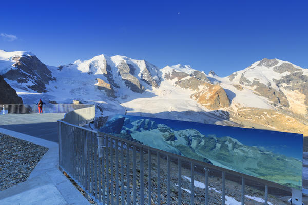 Tourist looks panorama from a panoramic terrace. Diavolezza Refuge, Bernina Pass, Engadin, Graubünden, Switzerland, Europe.