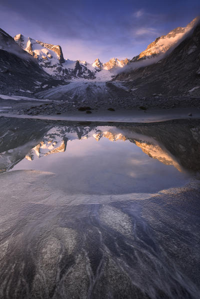 Sunrise from a pond at Forno Glacier, Forno Valley, Maloja Pass, Engadin, Graubünden, Switzerland, Europe.