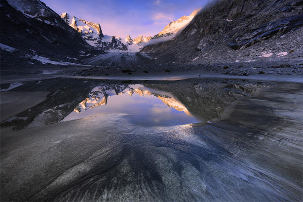 Sunrise from a pond at Forno Glacier, Forno Valley, Maloja Pass, Engadin, Graubünden, Switzerland, Europe.