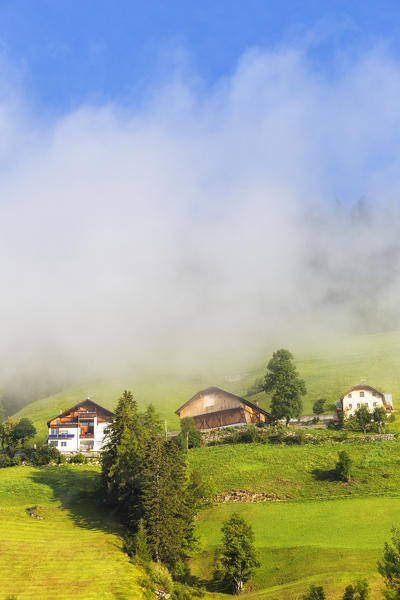 Fog near traditionl houses. Longiarù, Badia Valley, South Tyrol, Dolomites, Italy, Europe.