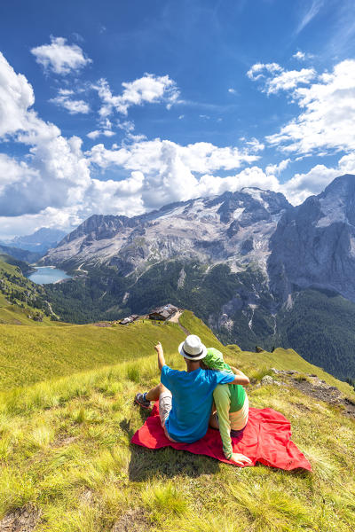 Tourists looks Viel del Pan Refuge with Marmolada in the background. Pordoi Pass, Fassa Valley, Trentino, Dolomites, Italy, Europe. (MR)