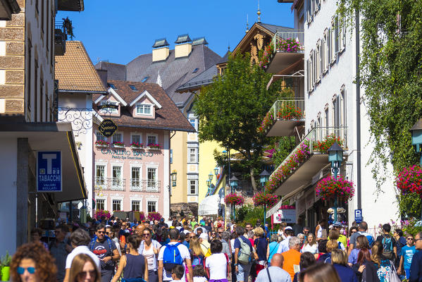 Tourists walks along the main street of Ortisei, Gardena Valley, Dolomites, South Tyrol, Italy, Europe.