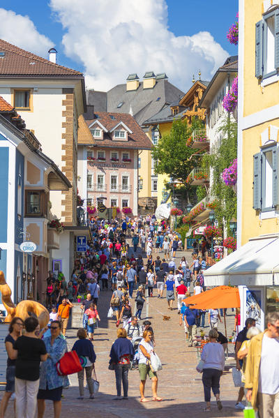 Tourists walks along the main street of Ortisei, Gardena Valley, Dolomites, South Tyrol, Italy, Europe.