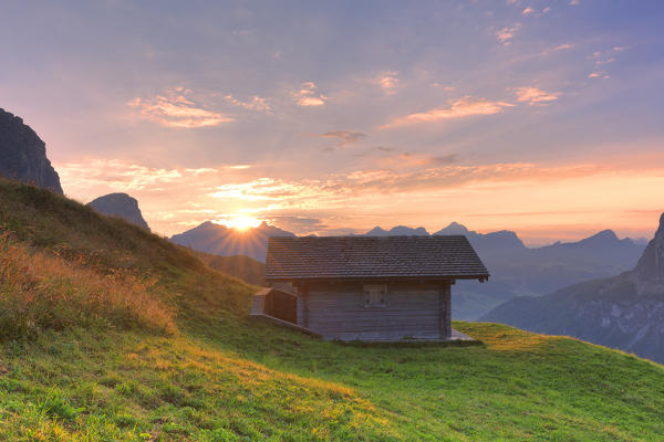 Traditional hut during sunrise at Gardena Pass, Gardena Valley, Dolomites, South Tyrol, Italy, Europe.