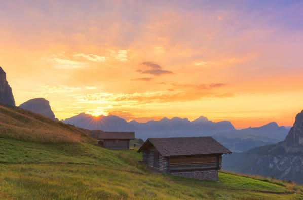 Traditional huts during sunrise at Gardena Pass, Gardena Valley, Dolomites, South Tyrol, Italy, Europe.