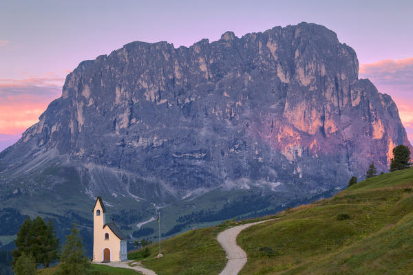 San Maurizio Chapel at sunrise with Sassolungo in the background. Gardena Pass, Gardena Valley, Dolomites, South Tyrol, Italy, Europe, Europe.