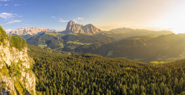 Elevated view of the forest above Gardena Valley with view on Sassolungo Group. South Tyrol, Dolomites, Italy, Europe.