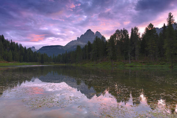 Three Peaks of Lavaredo are reflected in the Antorno Lake during sunrise. Dolomites of Sesto / Sexten, Province of Belluno, Veneto, Italy, Europe.