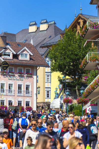 Tourists walks along the main street of Ortisei, Gardena Valley, Dolomites, South Tyrol, Italy, Europe.