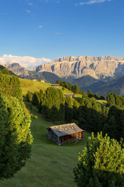 Last rays of sun on traditional hut with view on Sella Group. Gardena Valley, South Tyrol, Dolomites, Italy, Europe.