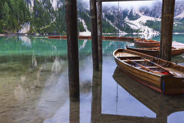 Boats moored under the stilt house. Braies Lake / Pragser Wildsee,  Braies / Prags, Dolomites, South Tyrol, Italy,  Europe.