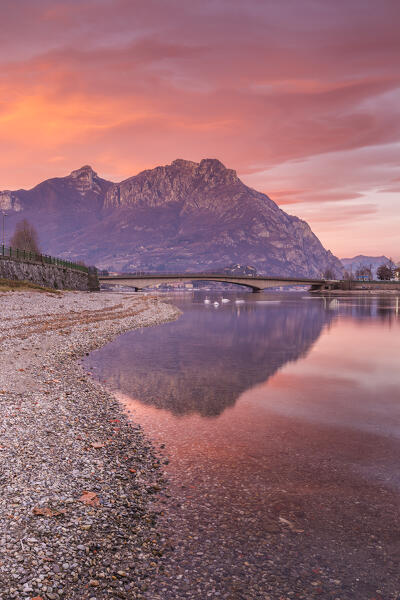 Sunrise on Lecco mountains (Moregallo, Corni di Canzo) reflected into the Adda River, Lecco city, lake Como, Lombardy, Italy, Europe