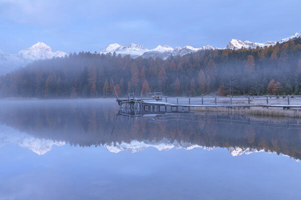 Foggy dawn on Lej da Staz (Lake of Staz) in autumn time. Celerina/Schlarigna, St Moritz, canton of Graubünden, Engadine, Switzerland, Europe