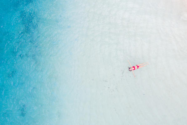 San Blas islands, Comarca Guna Yala, Panama, Central America. A young woman floating in turquoise water (MR)